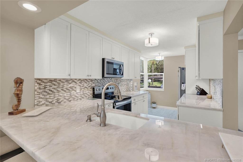 1950 Southwest Palm City Road, Unit 9108 Stuart, FL 34994 - Photo 10 of 37 a kitchen with granite countertop a sink stove and cabinets
