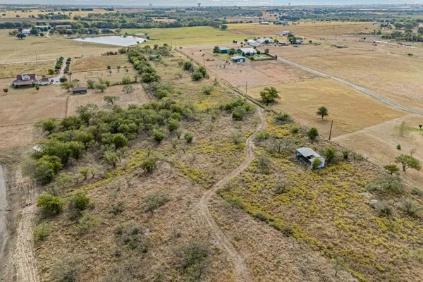 a view of a dry yard with green space