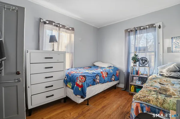 a bedroom with a bed and a flat tv screen on dresser