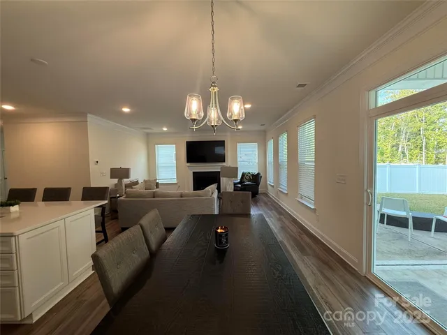 a living room with furniture a large window and a chandelier