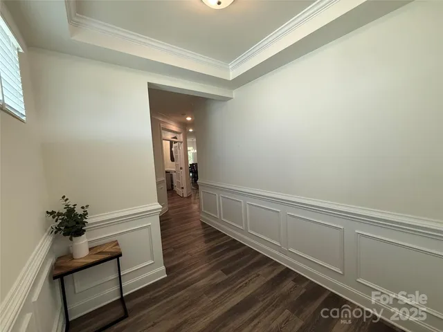 a hallway with wooden floor and a potted plant