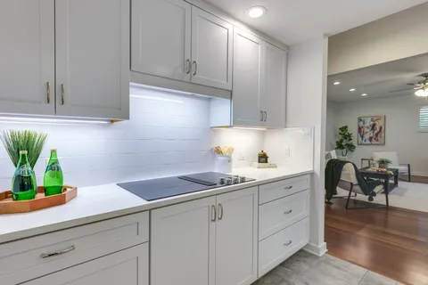 a kitchen with white cabinets and a potted plant