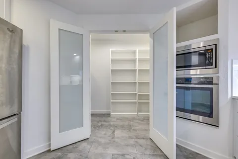 a living room with cabinets and stainless steel appliances