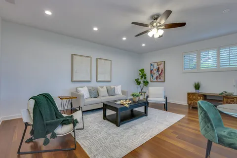 a living room with furniture and a ceiling fan