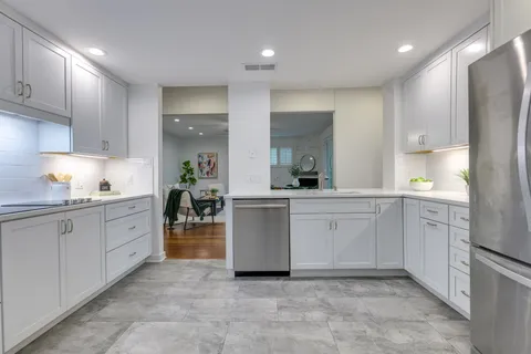 a kitchen with white cabinets and white appliances