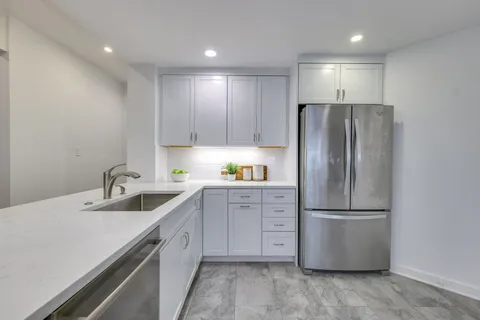 a kitchen with a refrigerator sink and cabinets
