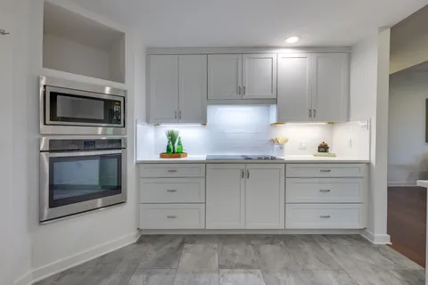 a kitchen with cabinets stainless steel appliances and sink