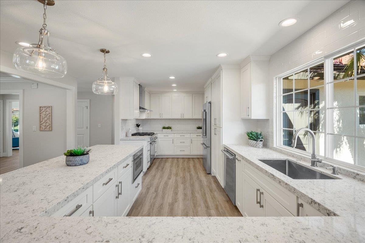 7106 Brooktree Way San Jose, CA 95120 - Photo 15 of 31 a large kitchen with kitchen island white cabinets and stainless steel appliances
