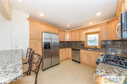 304 John Street Middlesex, NJ 08846 - Photo 19 of 25 a kitchen with stainless steel appliances granite countertop a stove a sink and a refrigerator