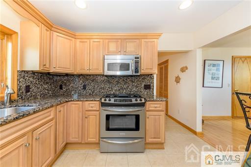 304 John Street Middlesex, NJ 08846 - Photo 21 of 25 a kitchen with stainless steel appliances granite countertop a stove and a sink
