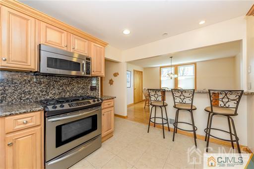 304 John Street Middlesex, NJ 08846 - Photo 22 of 25 a kitchen with stainless steel appliances kitchen island granite countertop a stove a refrigerator and a microwave
