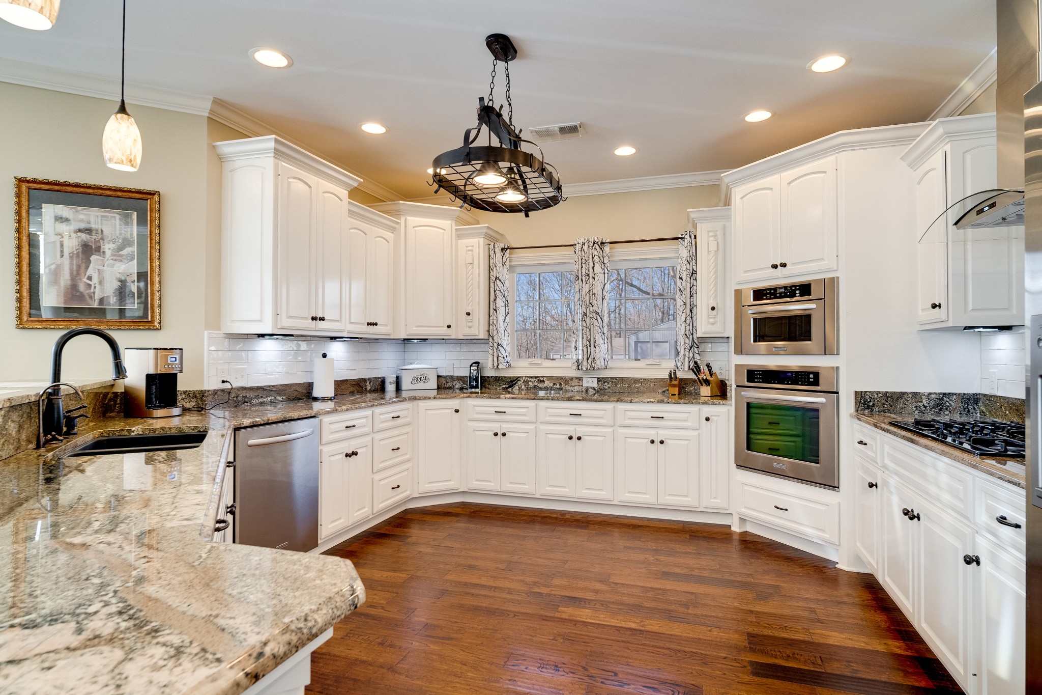 236 Raymond Hodges Road Cottontown, TN 37048 - Photo 19 of 37 a large kitchen with stainless steel appliances granite countertop a stove and white cabinets with wooden floor