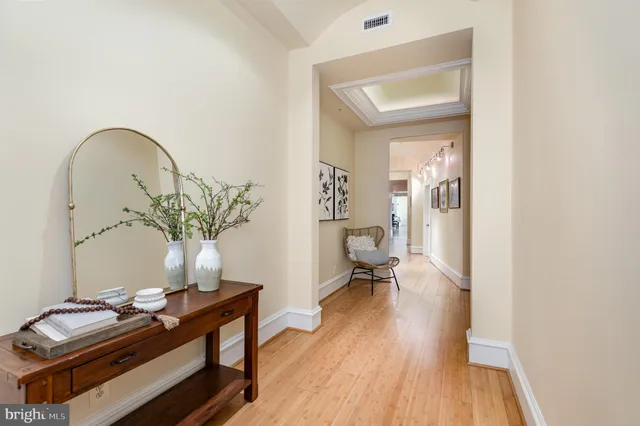 a kitchen with stainless steel appliances kitchen island granite countertop a refrigerator a sink dishwasher a stove and white cabinets with wooden floor