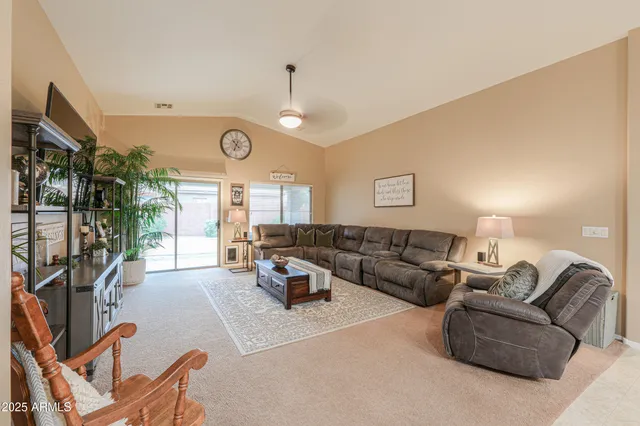 a living room with furniture a large window and a clock