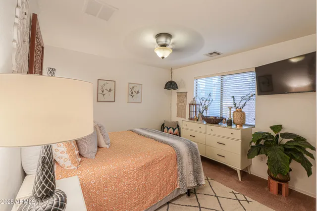 a bed room with a bed window and a flat screen tv