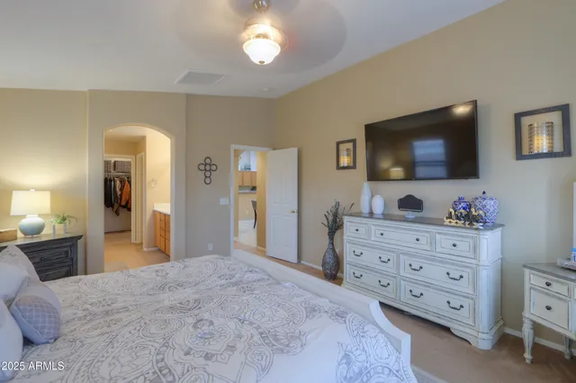 a bedroom with a bed and a flat tv screen on dresser