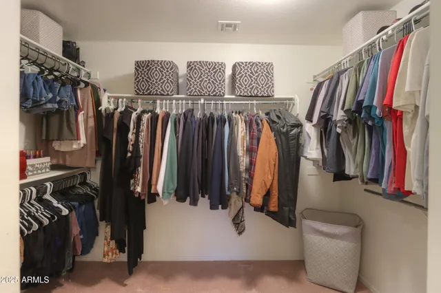 a view of walk in closet with clothes and shoes