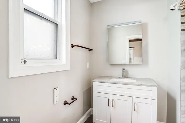 a bathroom with a granite countertop sink and a mirror