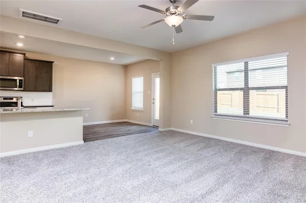 a view of an empty room with window and cabinet