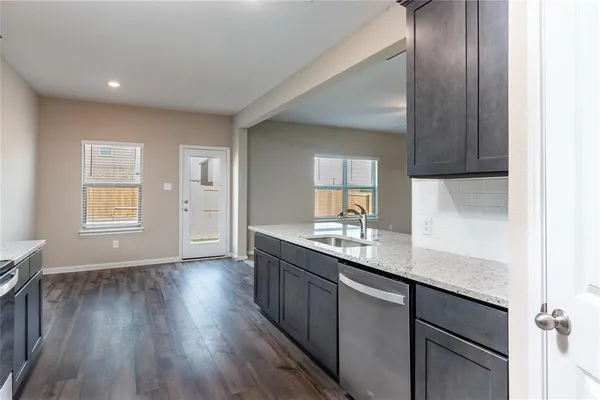 a kitchen with granite countertop wooden floors and white cabinets