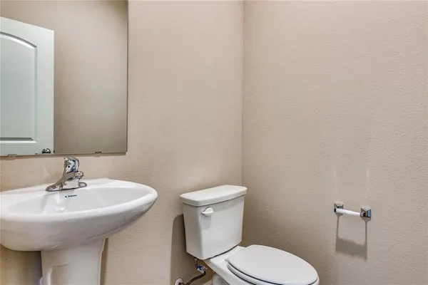 a bathroom with a sink a toilet and mirror