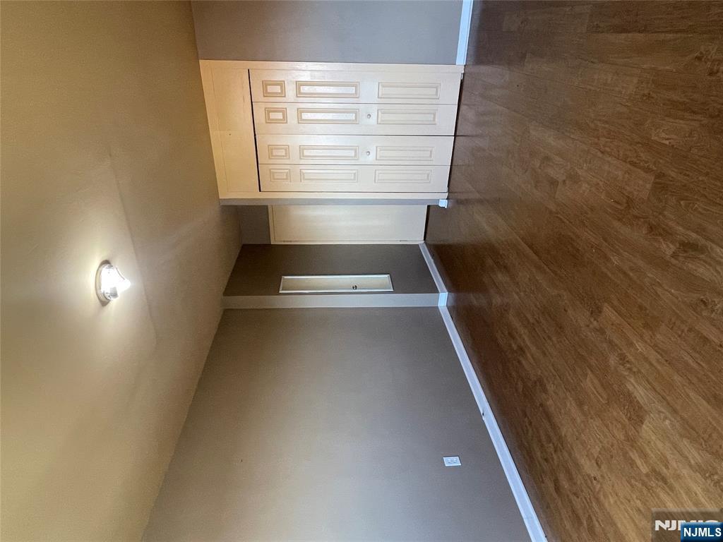 90 Prospect Avenue, Unit 8E Hackensack, NJ 07601 - Photo 11 of 21 a view of an empty room with wooden floor and a window