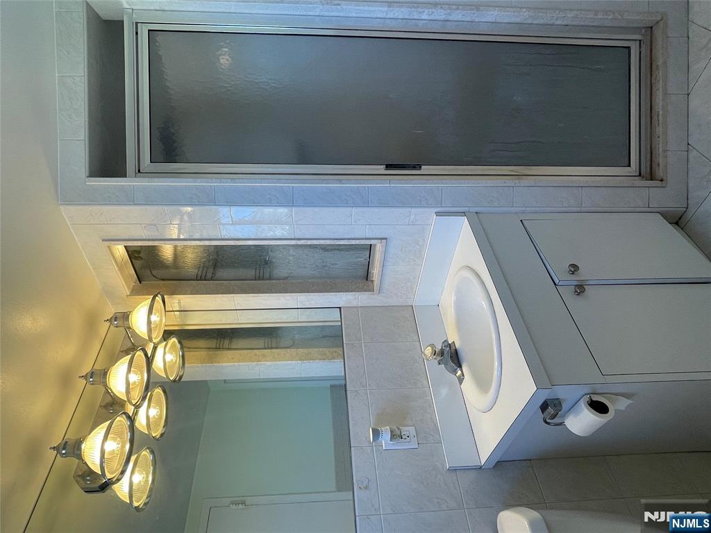 90 Prospect Avenue, Unit 8E Hackensack, NJ 07601 - Photo 13 of 21 a bathroom with a sink and a mirror