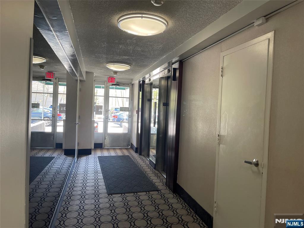 90 Prospect Avenue, Unit 8E Hackensack, NJ 07601 - Photo 20 of 21 a view of a hallway with wooden floor and staircase