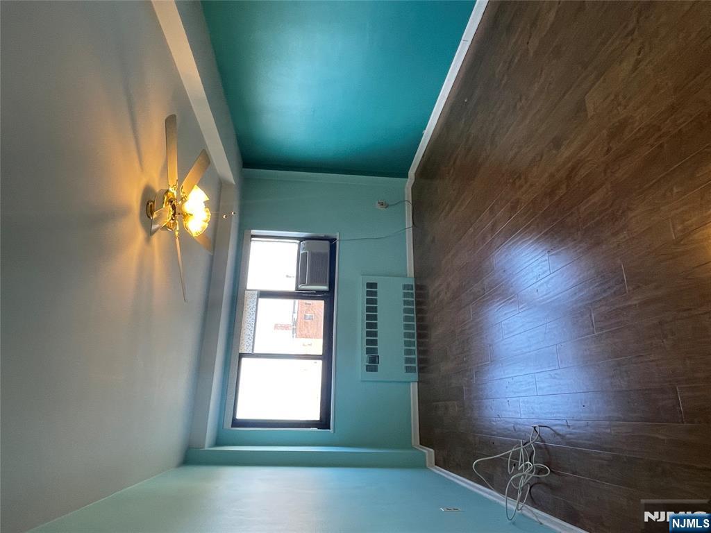 90 Prospect Avenue, Unit 8E Hackensack, NJ 07601 - Photo 6 of 21 an empty room with wooden floor and windows