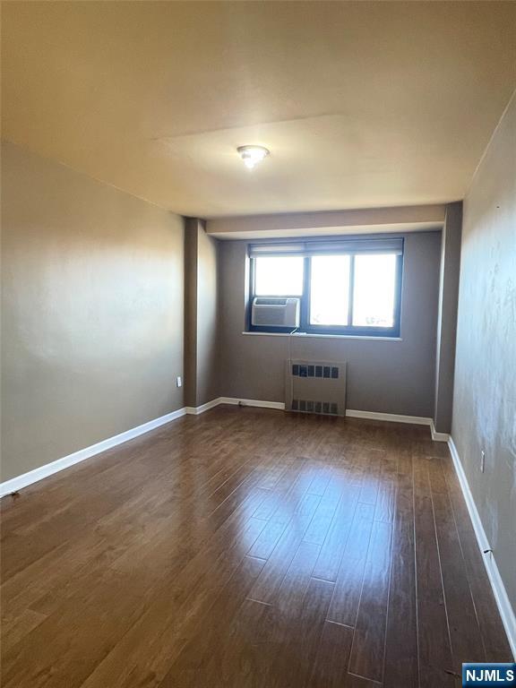 90 Prospect Avenue, Unit 8E Hackensack, NJ 07601 - Photo 10 of 21 an empty room with wooden floor and windows