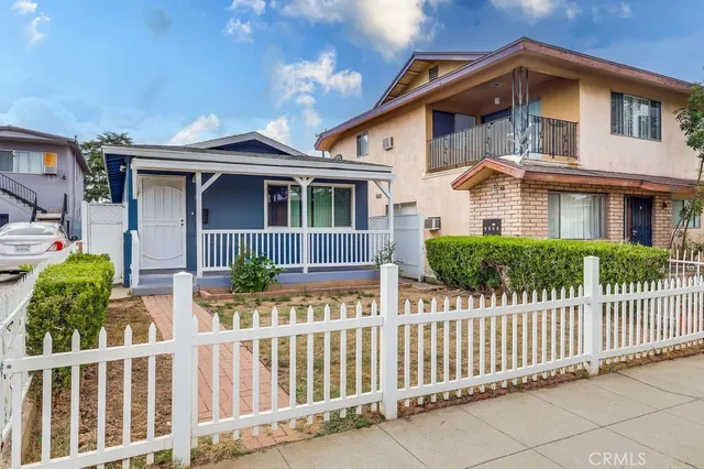 a front view of white house with a small yard