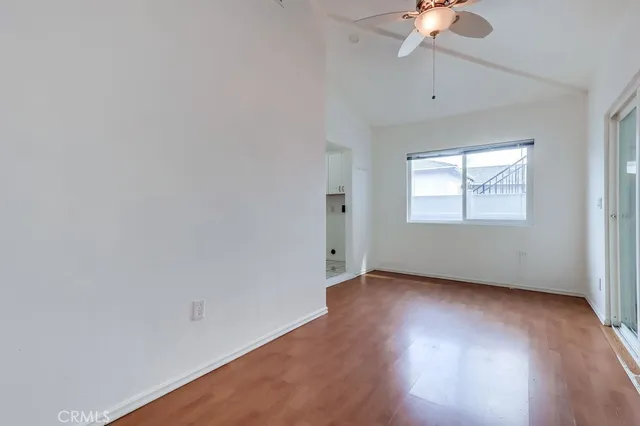 an empty room with a window and a chandelier fan