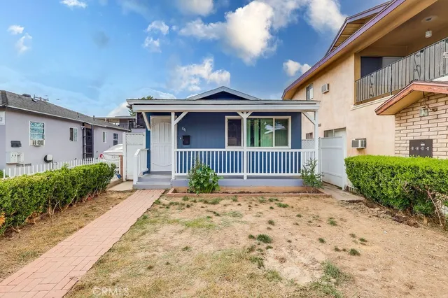 a front view of a house with a garden and yard