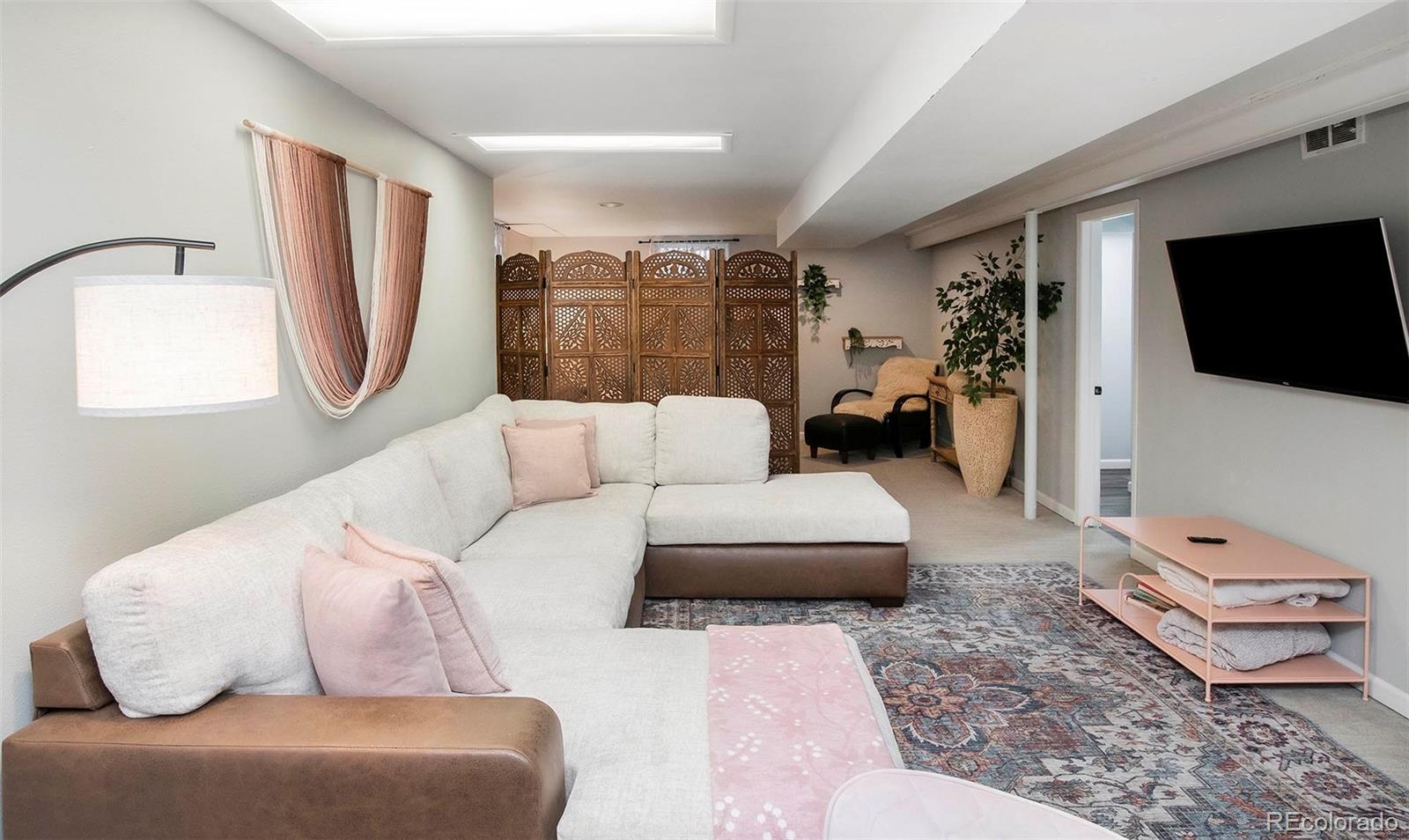 6480 Garrison Street Arvada, CO 80004 - Photo 26 of 40 a living room with furniture and a flat screen tv