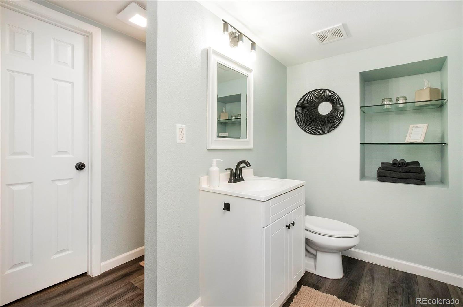 6480 Garrison Street Arvada, CO 80004 - Photo 29 of 40 a bathroom with a toilet a sink and a mirror