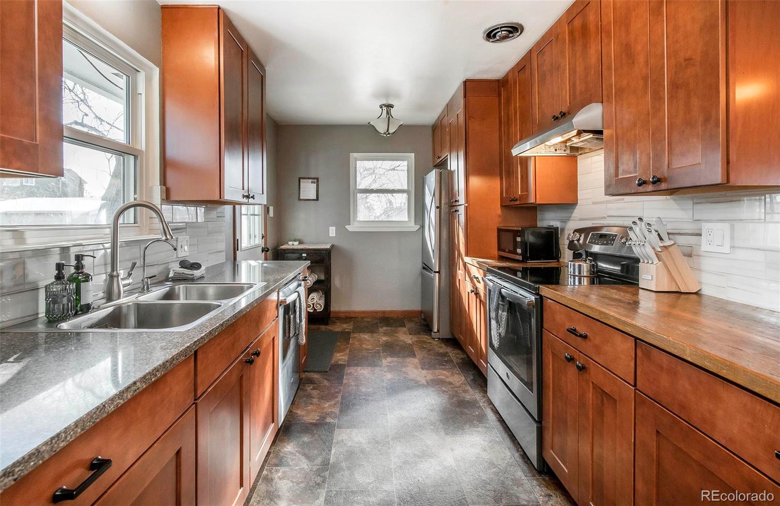 6480 Garrison Street Arvada, CO 80004 - Photo 10 of 40 a kitchen with stainless steel appliances a sink stove and cabinets