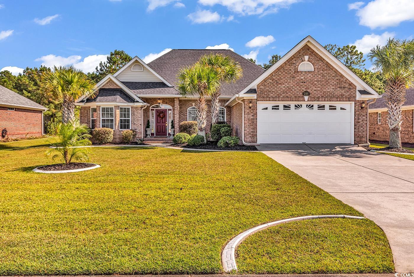 View of front facade featuring a front lawn, brick siding, driveway, roof with shingles, and an attached garage