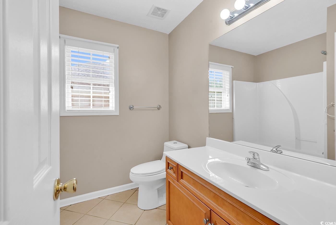 246 Catawba River Road Myrtle Beach, SC 29588 - Photo 13 of 27 Bathroom featuring light tile patterned floors, vanity, and a shower