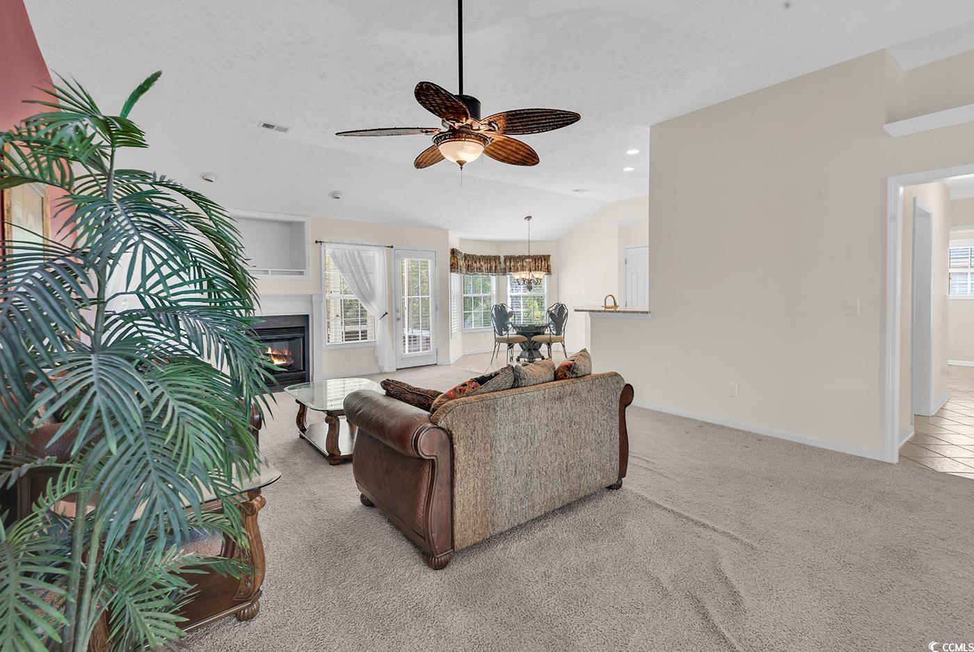 246 Catawba River Road Myrtle Beach, SC 29588 - Photo 20 of 27 Carpeted living room featuring ceiling fan, vaulted ceiling, a glass covered fireplace, recessed lighting, and a textured ceiling