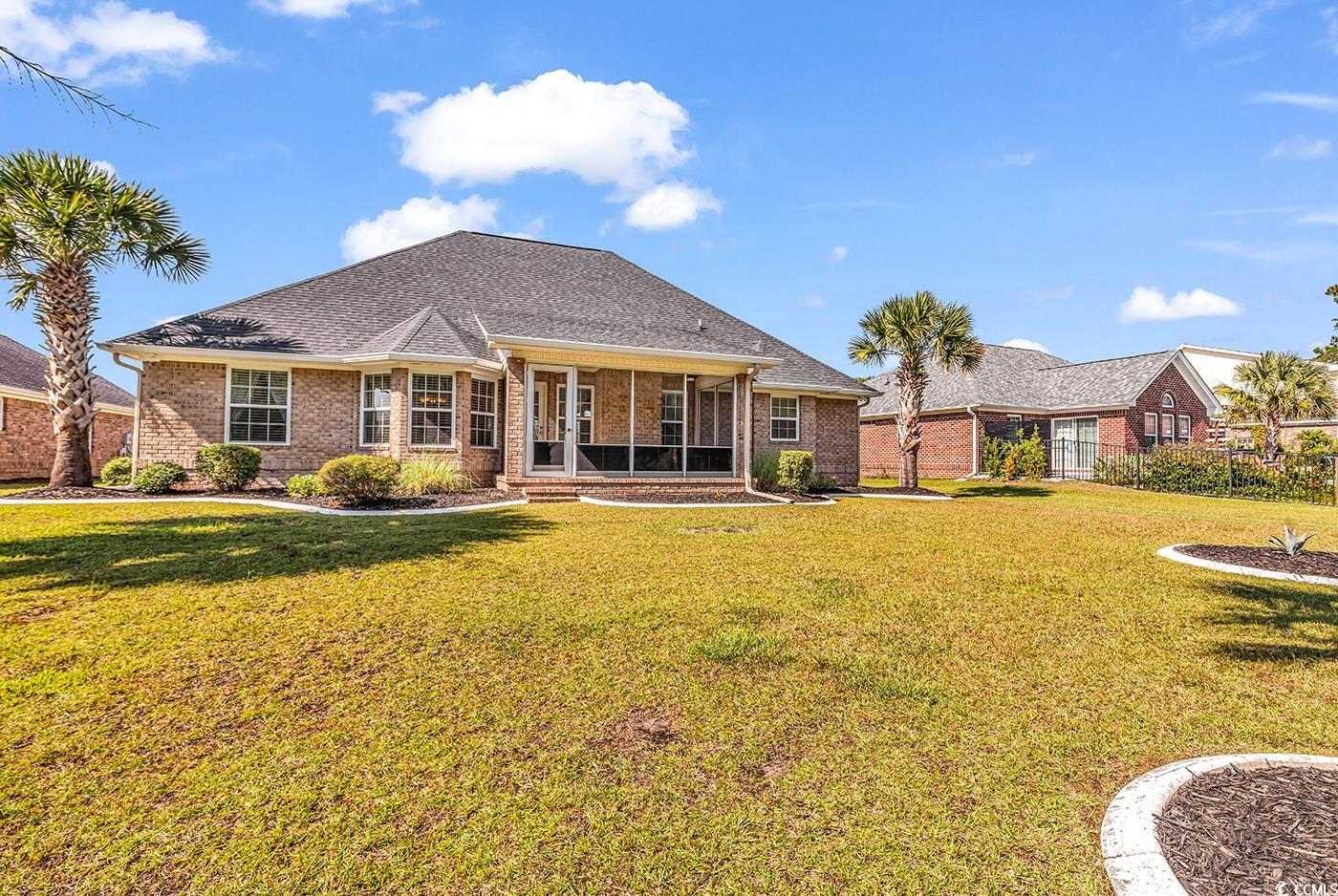 246 Catawba River Road Myrtle Beach, SC 29588 - Photo 25 of 27 Back of property featuring a yard, brick siding, a sunroom, and a shingled roof