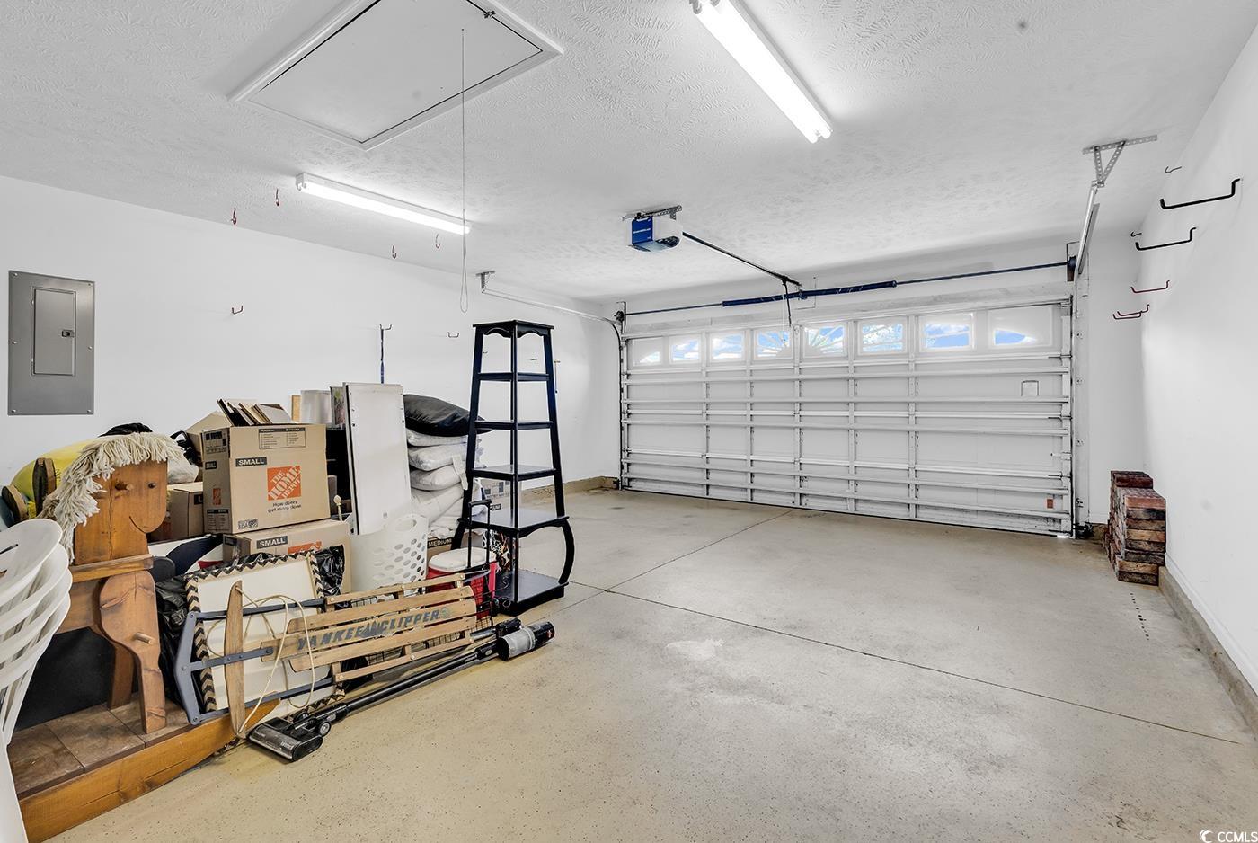 246 Catawba River Road Myrtle Beach, SC 29588 - Photo 9 of 27 Garage featuring electric panel and a garage door opener