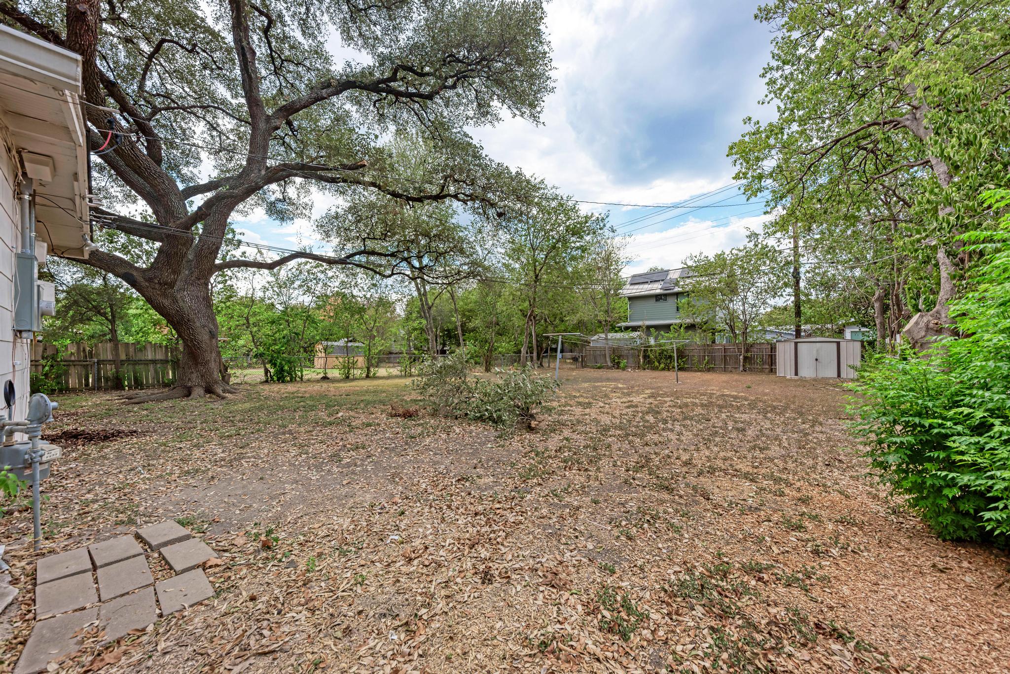 7804 Rutgers Avenue Austin, TX 78757 - Photo 21 of 32 Mature trees shade a spacious back lawn enclosed by perimeter fencing.