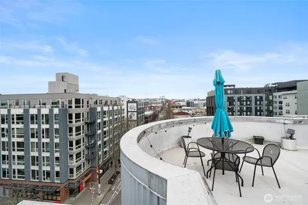 a roof deck with table and chairs and potted plants