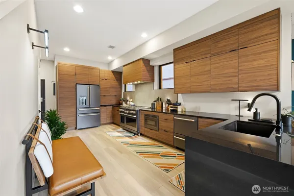 a kitchen with stainless steel appliances granite countertop a sink chairs and refrigerator