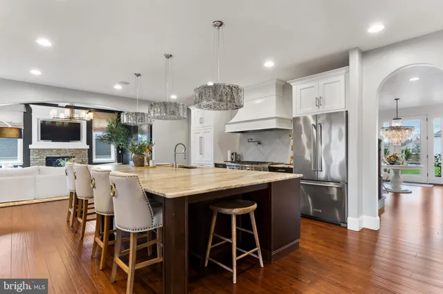 a bedroom with a large bed a chandelier and dresser