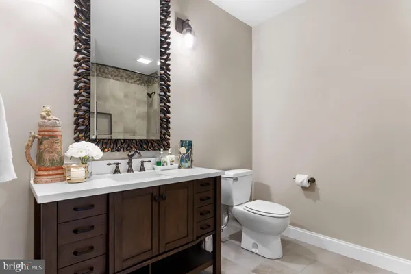 a kitchen with stainless steel appliances kitchen island granite countertop a stove top oven a sink dishwasher and white cabinets with wooden floor
