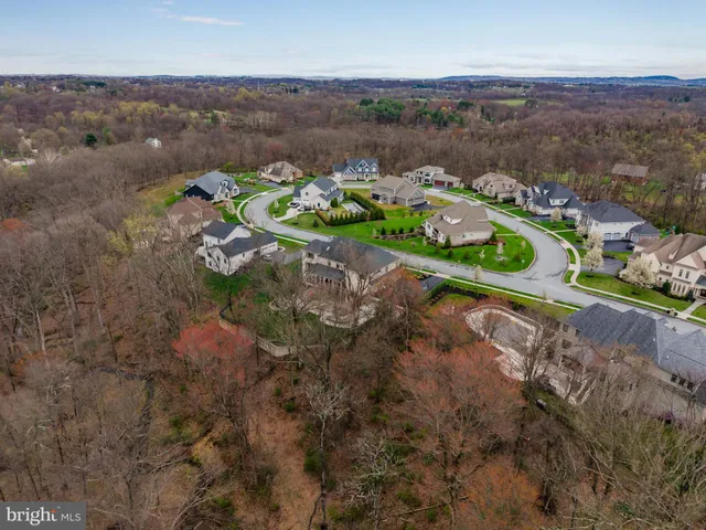 an aerial view of a house with a yard and green space