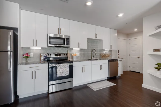 a kitchen with granite countertop white cabinets and white appliances