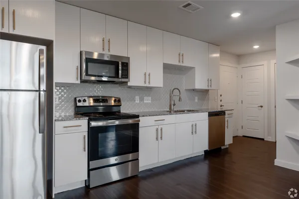 a kitchen with stainless steel appliances granite countertop a refrigerator stove a sink and a microwave