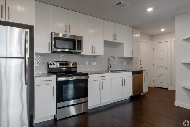 a kitchen with stainless steel appliances granite countertop a refrigerator stove a sink and a microwave